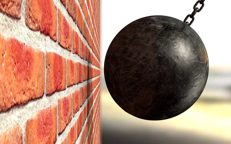 A wrecking ball about to hit brickwall