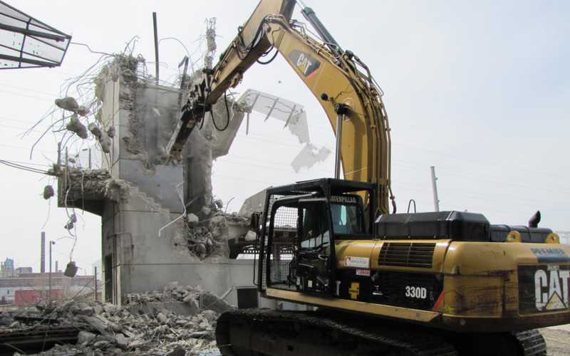 A bulldozer demolishing a building