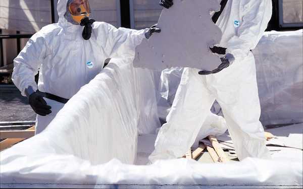 Two people handling asbestos material