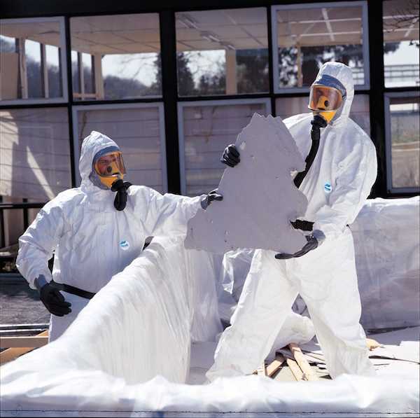 Two people handling asbestos material